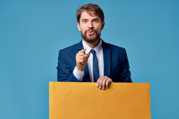 emocjonalny mężczyzna reklama żółty baner prezentacja niebieski tło - Zdjęcie, obraz