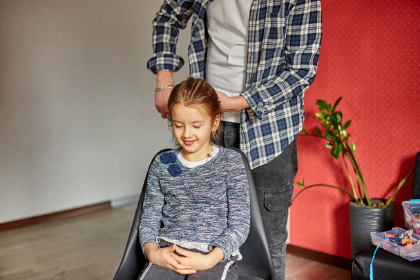 Père peignant, brossant les cheveux de sa fille à la maison, père et fille souriant, moments de famille, passer du temps ensemble. - Photo, image