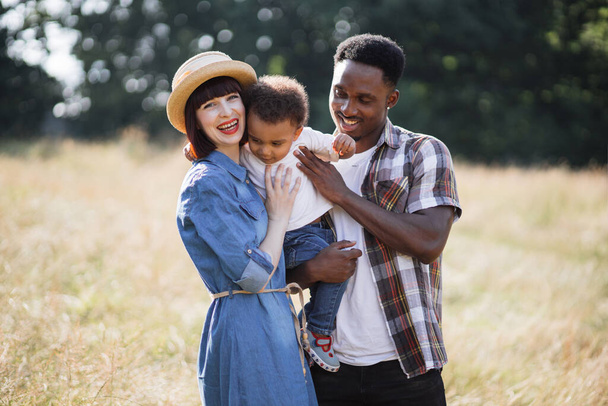 Happy multiracial family standing in hugs on nature - Фото, зображення