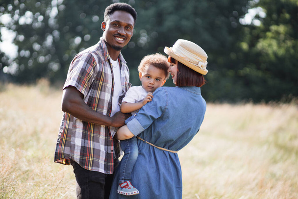 Caucasian woman and african man posing with son on nature - Fotografie, Obrázek