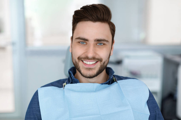 Jeune homme patient souriant en dentisterie, espace de copie - Photo, image