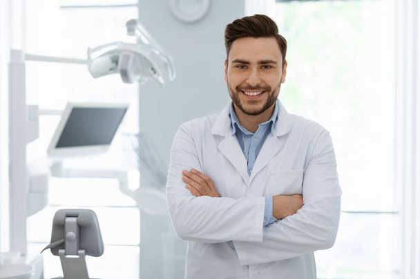Homem alegre médico posando na mais nova clínica odontológica - Foto, Imagem