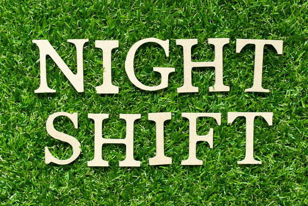 Wood letter in word night shift on green grass background - Photo, Image
