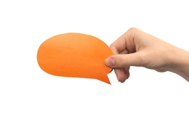 Orangefarbene runde Sprechblase in der Hand isoliert auf weißem Hintergrund. Feedback geben, Kommunikationskonzept. Leere Textbox-Attrappe aus Pappe - Foto, Bild