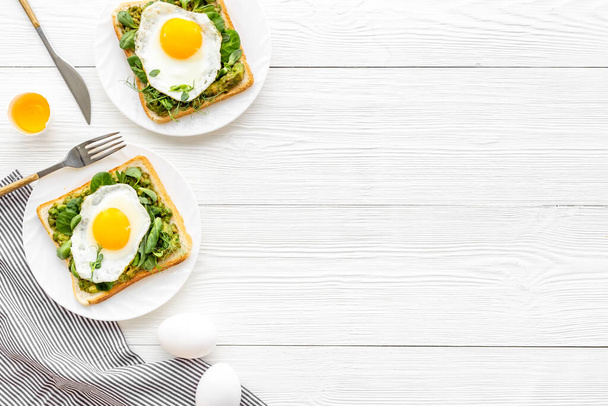 Eggs and avocado with spinach on toasted bread. Top view - Foto, Bild