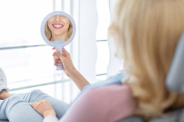 Beautiful healthy smile in dental mirror reflection - Photo, Image