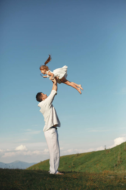 Baba dağlarda küçük kızıyla oynuyor. - Fotoğraf, Görsel