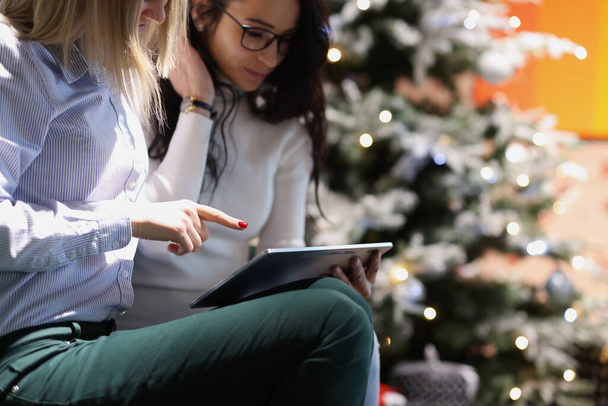 二人の若い笑顔の女性オンラインショッピングのためにクリスマスクローズアップ - 写真・画像