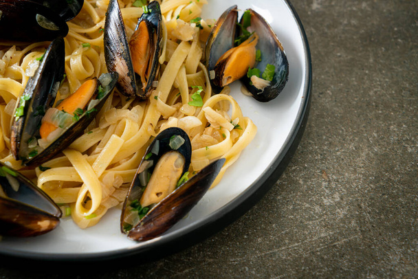 linguine spaghetti pasta vongole white wine sauce - Italian seafood pasta with clams and mussels - Foto, Imagen