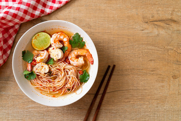 noodles with spicy soup and shrimps in white bowl (Tom Yum Kung)  - Asian food style - Foto, Bild