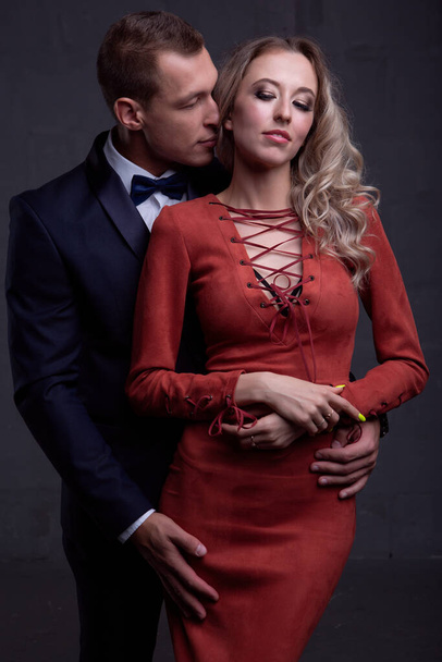 sexy elegant couple in love in evening dresses on a dark background. Studio photo - Photo, image