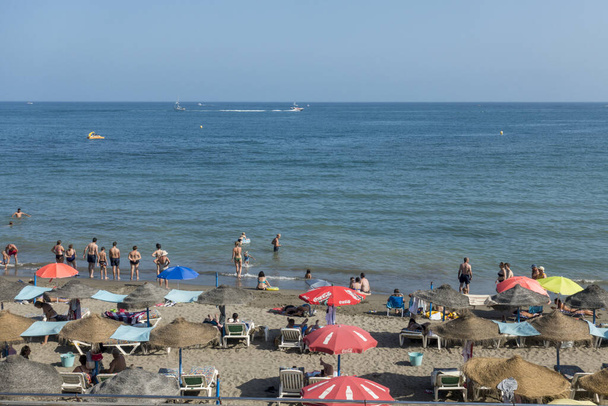 BENALMADENA, SPAIN - Aug 18, 2021: A busy beach with parasols at Benalmadena, Spain - Zdjęcie, obraz