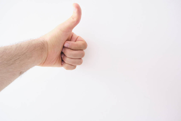 A closeup shot of a hand doing a thumbs-up gesture - Photo, Image