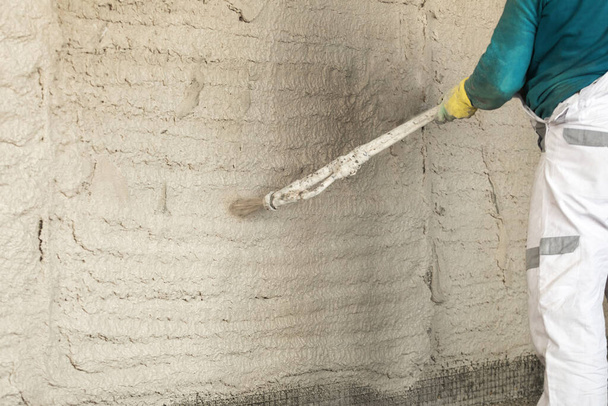 The process of applying plaster to walls inside a building by machine. - Fotografie, Obrázek