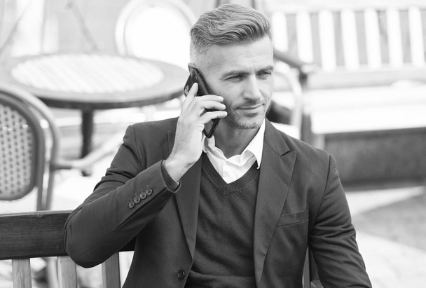 Youre never alone with cellphone. Businessman make phone call outdoors. Call answering. Phone conversation. Mobile communication. Modern technology. 3G. 4G - Zdjęcie, obraz