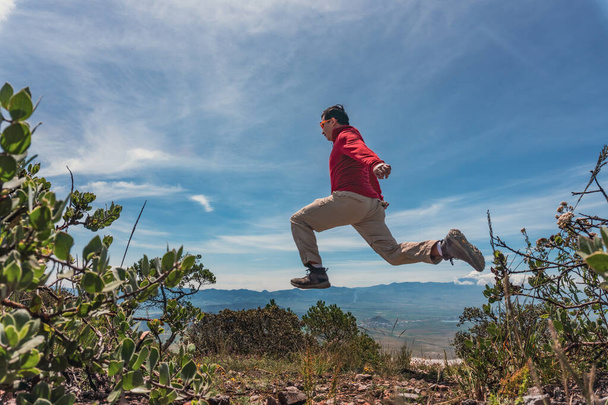 man jumping over rocks in mountain - Photo, Image
