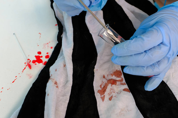 fresh splatter of blood on white table, stains on tissue at crime scene, blood sample collection tube, forensic scientist examining samples, forensic medical examiner work concept, police laboratory - Φωτογραφία, εικόνα