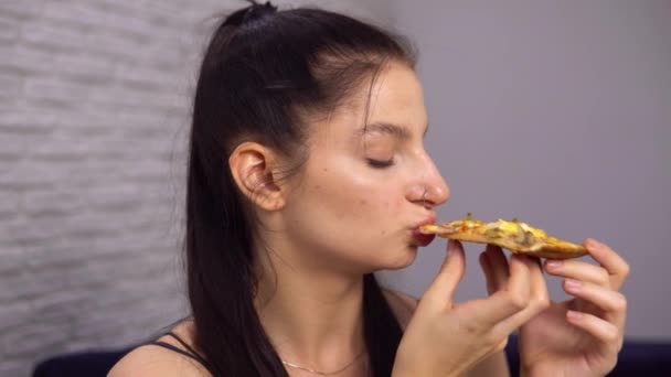 Donna Godersi una pizza gustosa, mordere fetta di pizza. Dipendenza da fast food.  - Filmati, video