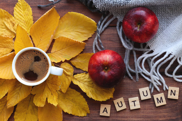 Cozy autumn composition with cup of coffee, apples warm plaid, yellow autumn leaves and inscription AUTUMN. Top view, flat lay - Fotoğraf, Görsel