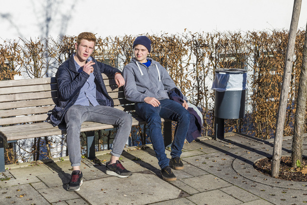 Coole Jungs sitzen auf einer Bank - Foto, Bild
