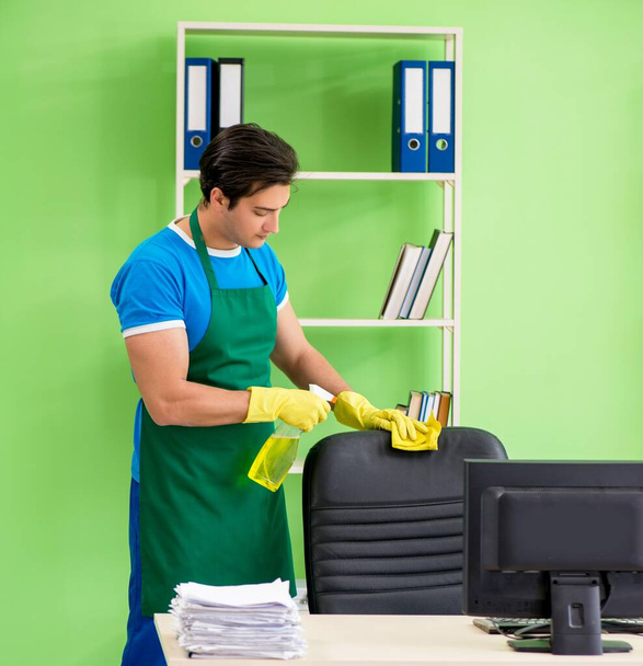 Чоловічий красивий професійний прибиральник працює в офісі
 - Фото, зображення