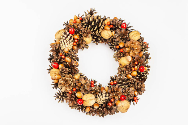Autumn wreath of cones, nuts, and berries isolated on white background. Creative composition, the handmade. Home decoration festive concept - Photo, Image