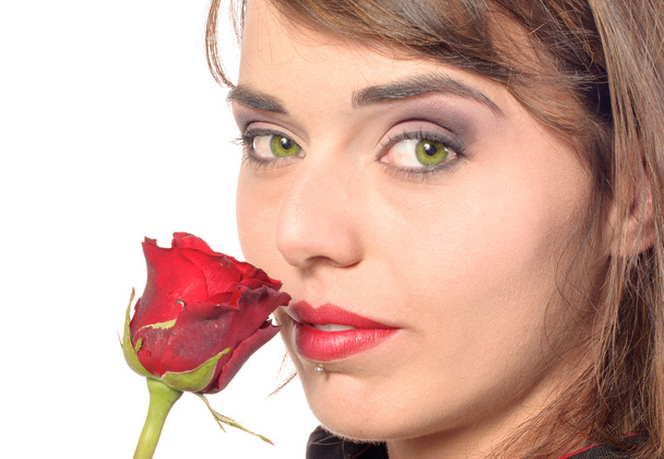 sonriente chica vestida con una capa negra huele una rosa roja
 - Foto, Imagen