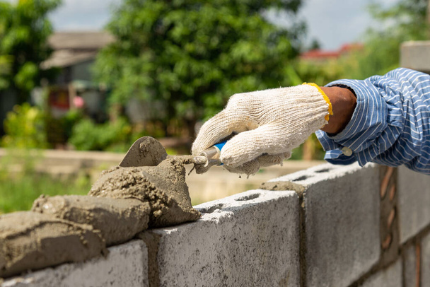 muratore fare muro di cemento da blocco di cemento e intonaco in cantiere
. - Foto, immagini