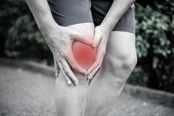 У человека воспаление и отек в колене, травма колена, тендинит - Фото, изображение