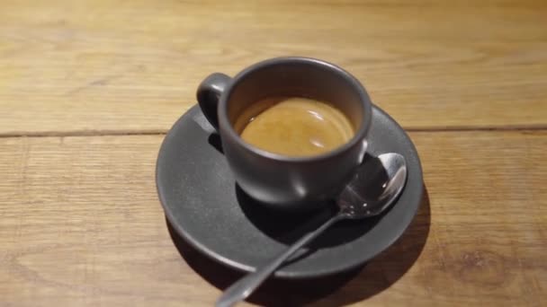 Kuppi espressoa lautasella teelusikallisen vieressä..  - Materiaali, video