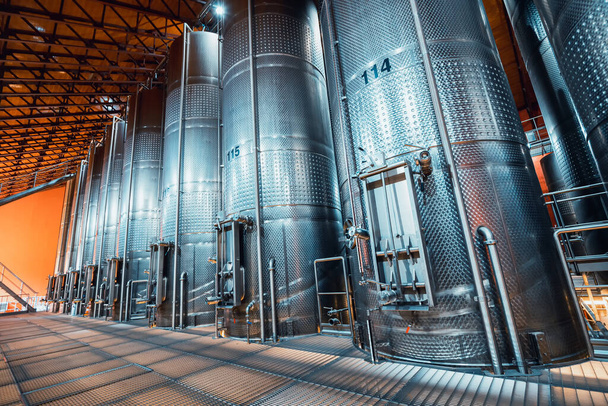 ワイナリーの工場でワインやビールを発酵させる大きな金属製のバット。アルコール飲料の製造のための技術及び設備の概念 - 写真・画像