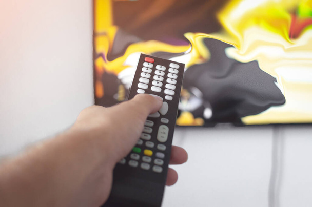 Person holding the remote control or TV remote. Remote control in hand closeup. First-person view. - Foto, Imagem