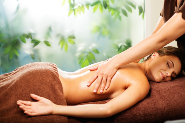 Beautiful young woman having massage in a spa salon - Photo, Image