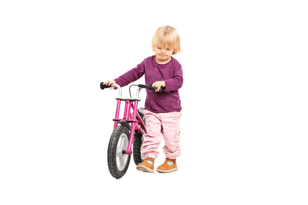 Baby girl pushing small bike - Foto, immagini