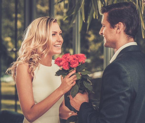 Красивый мужчина с кучей красных роз встречается со своей девушкой
 - Фото, изображение