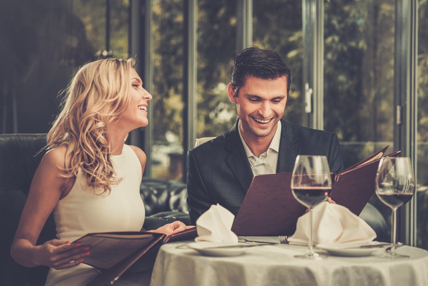 レストランのメニューと陽気なカップル  - 写真・画像