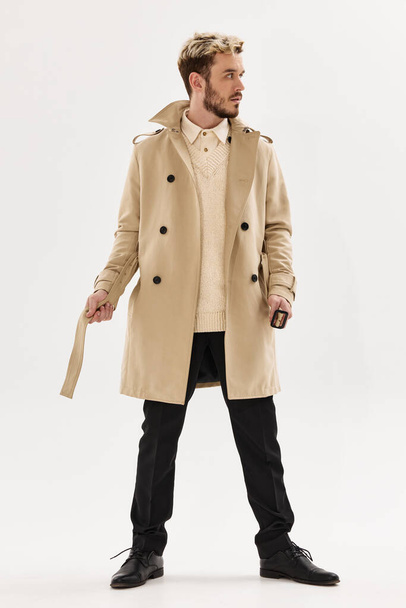 man in beige coat fashion posing modern style - Foto, Imagen