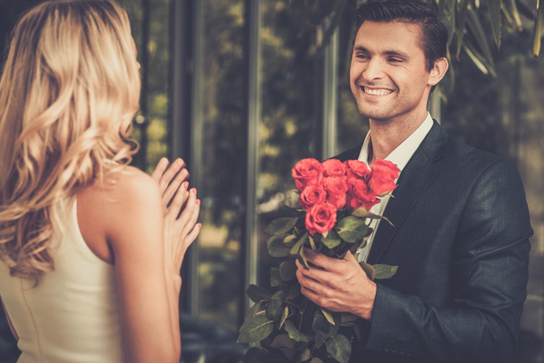 Bel homme avec un tas de roses rouges sortir ensemble sa dame
 - Photo, image