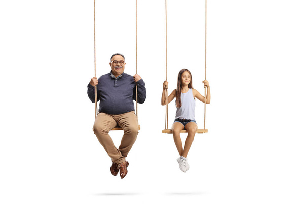 Happy grandfather and granddaughter playing on swings isolated on white background - Φωτογραφία, εικόνα