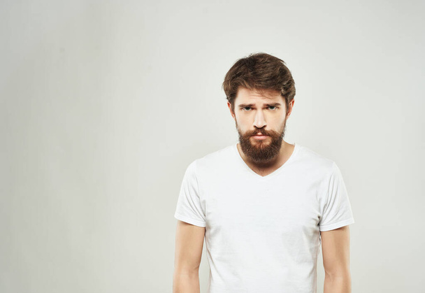 hombre emocional en una camiseta blanca mano gestos ira de cerca - Foto, Imagen