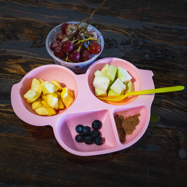 Comida divertida para niños. Lindo plato en forma de coche con frutas frescas - manzana, uvas, arándanos y guayaba - para un desayuno saludable. - Foto, Imagen
