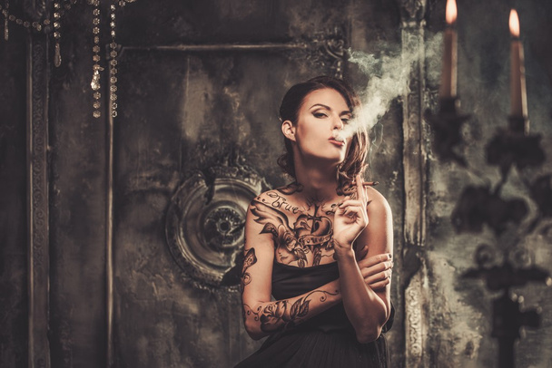 Smoking tattooed beautiful woman  in old spooky interior - Fotoğraf, Görsel
