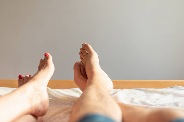 Feet of couple on the bed. Man and woman resting love on bed.Sex on vacation theme. Valentine and Honeymoon of lovers concept.Closeup.Copy space. - 写真・画像