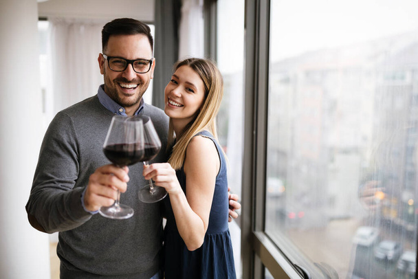 Happy couple in love drinking wine and having romantic date - 写真・画像