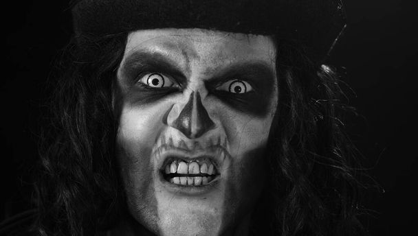 Frightening man in skeleton Halloween makeup screaming, shouting, making faces, trying to scare - Photo, Image