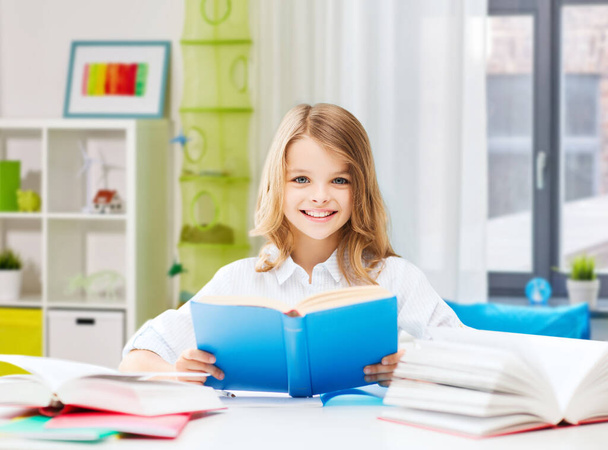 szczęśliwy uśmiechnięty student dziewczyna czytanie książki w domu - Zdjęcie, obraz