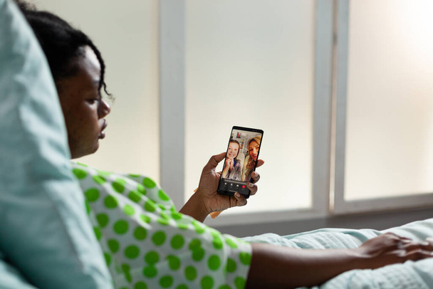 Patiënt van Afrikaanse Amerikaanse etniciteit met behulp van smartphone - Foto, afbeelding