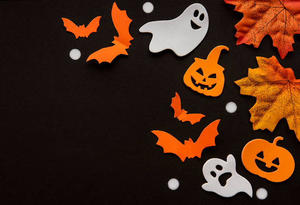 Modern background with bats,  pumpkins, leaves on a black background. Halloween with copy space for text. Flat lay, top. - Photo, Image
