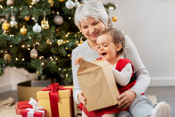 grandmother and baby girl with christmas gifts - Фото, изображение