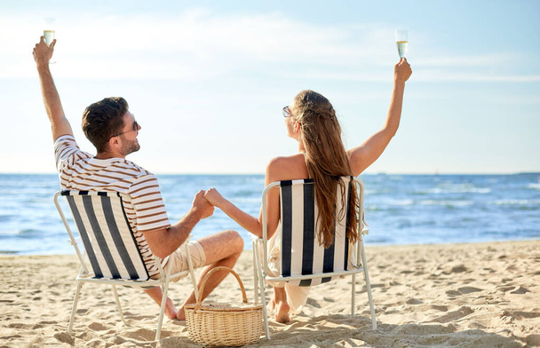 happy couple drinking champagne on summer beach - Foto, imagen
